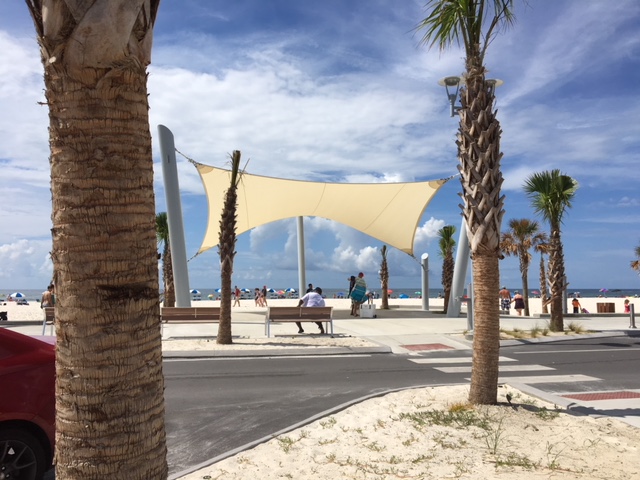 Sun shade sail canopy on the beach next to palm trees