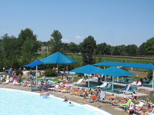 Sun shade structures covering pool seating at Bluejacket Park Pool